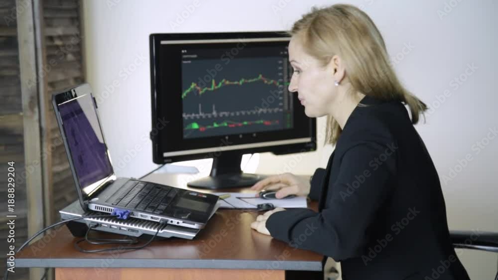 Work on a stock exchange. Businesswoman watching changes in the currency exchange chart Work on a stock exchange. Businesswoman watching changes in the currency exchange chart