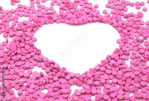 Pink pill is heart shaped. Creative healthcare and medicine concept  isolated on white background . Space for text and images.