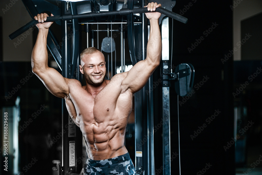 Brutal strong bodybuilder athletic men pumping up muscles with dumbbells. Brutal strong bodybuilder athletic men pumping up muscles with dumbbells.
