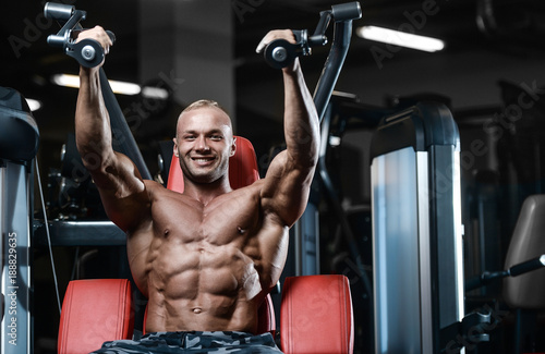 Brutal strong bodybuilder athletic men pumping up muscles with dumbbells. © antondotsenko