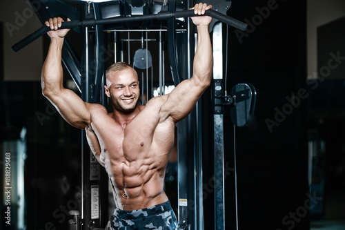 Brutal strong bodybuilder athletic men pumping up muscles with dumbbells.