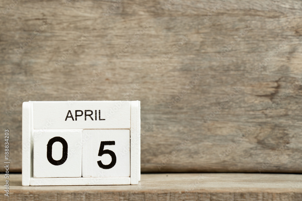 White block calendar present date 5 and month April on wood background White block calendar present date 5 and month April on wood background