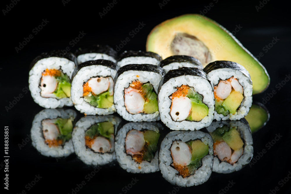 Fresh delicious Japanese sushi with avocado, cucumber, shrimp and caviar on dark background Fresh delicious Japanese sushi with avocado, cucumber, shrimp and caviar on dark background