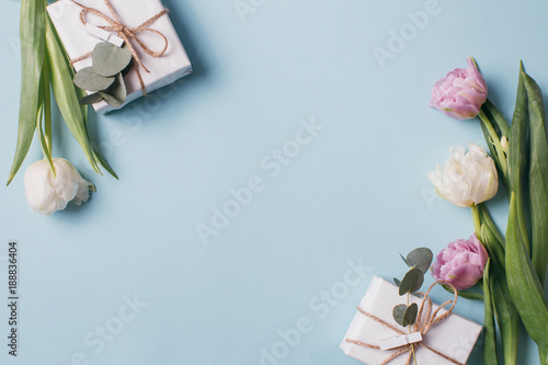 Fototapeta Naklejka Na Ścianę i Meble -  Mother's Day Composition: Violet and white tulips and a gift boxes on a blue background. Top view.Flat lay.