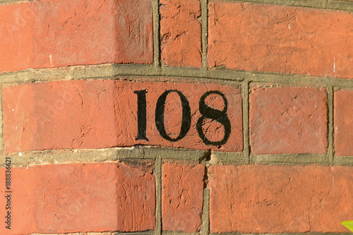 House number 108 sign painted on wall