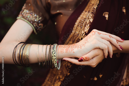 Woman Hands with black mehndi tattoo. Hands of Indian bride girl with black henna tattoos. Fashion. India