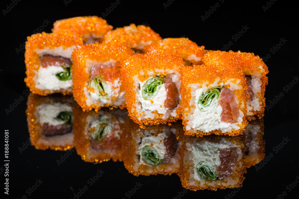 Traditional Japanese cuisine. Tasty sushi rolls with rice, cream cheese, shrimps, avocado on dark background