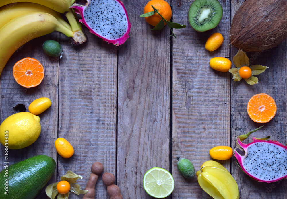 Mix of ripe tropical fruits with avocado, mango, coconut, carambola, banana, kumquat, pitahaya, kiwi. Superfood background. Vegetarian food. Copy space Mix of ripe tropical fruits with avocado, mango, coconut, carambola, banana, kumquat, pitahaya, kiwi. Superfood background. Vegetarian food. Copy space