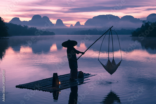 Fisherman is fishing in the lake during sunrise in Krabi, Thailand. © BUSARA