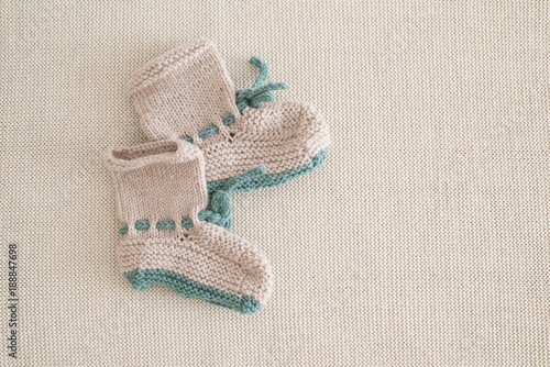 kleine handgestrickte Babyschuhe auf wollenem Hintergrund