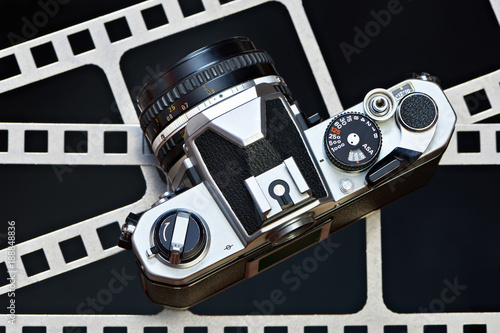 Fotografie Retro SLR camera on background of perforation film
