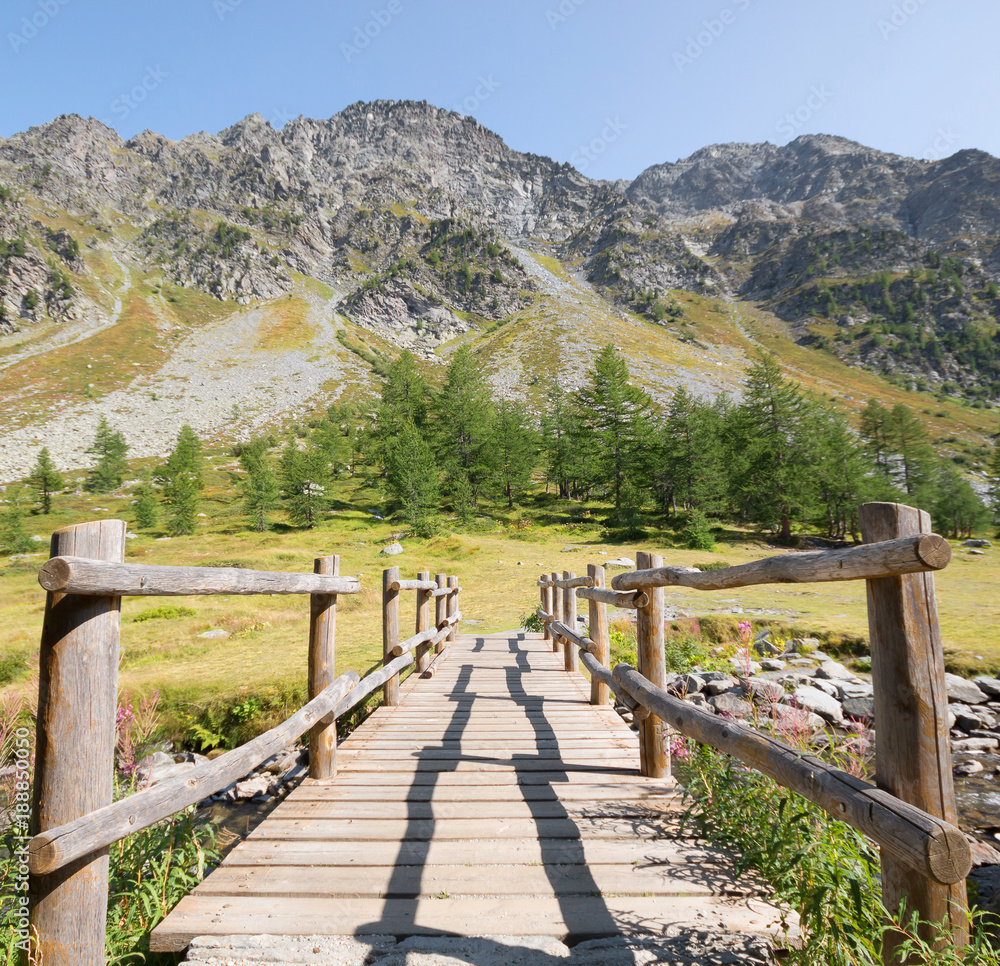 Fototapeta Widok górski z drewnianym mostem w natura krajobrazu tle