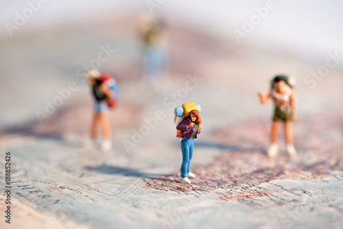 Group of miniature young travellers with backpacks