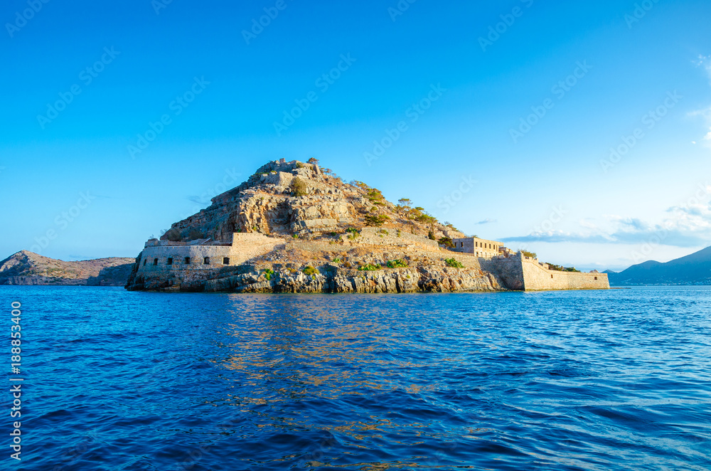 Fototapeta premium View of the island of Spinalonga with calm sea. Here were isolated lepers, humans with the Hansen's desease, gulf of Elounda, Crete, Greece. 