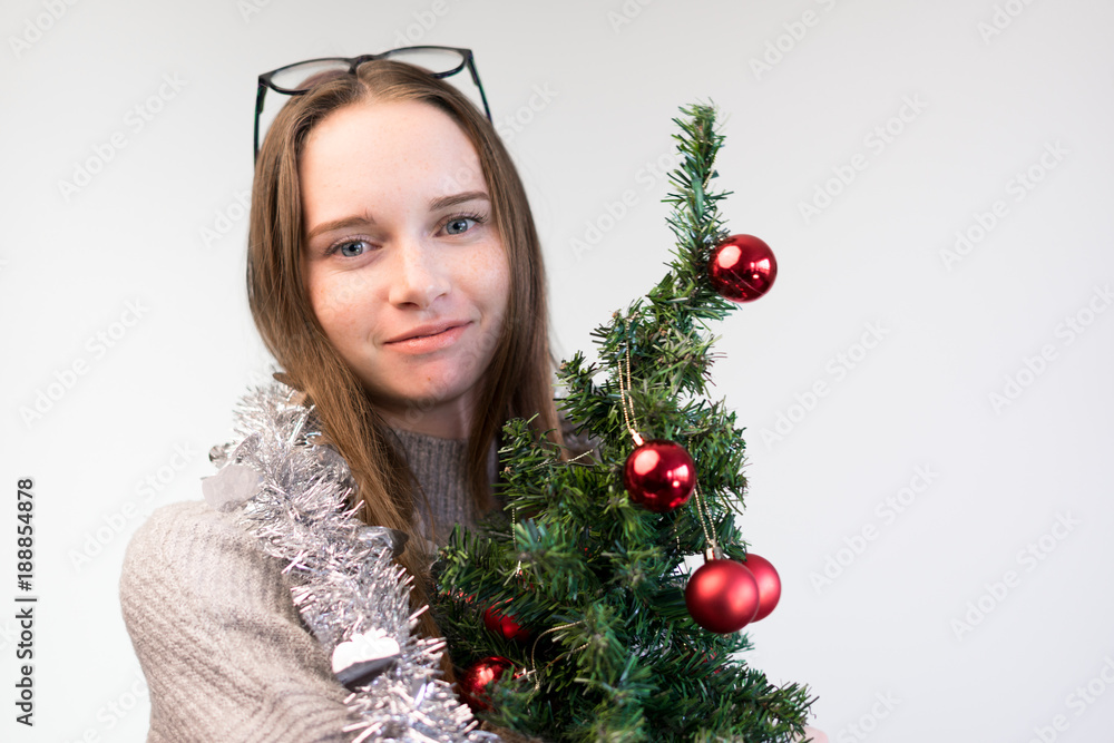girl with a small Christmas tree smiling girl with a small Christmas tree smiling