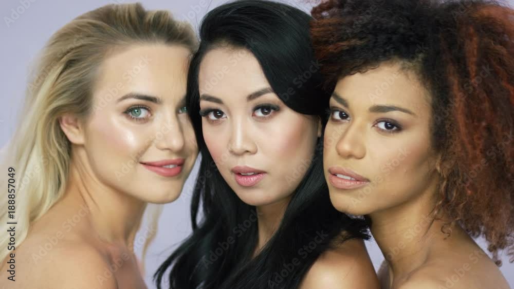 Portrait of three charming wonderful young women friends standing together and looking at camera in studio. Portrait of three charming wonderful young women friends standing together and looking at camera in studio.