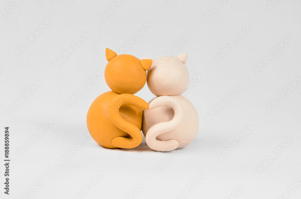 Two minimalistic animal figures in love. Lovely cat plasticine models having tails in heart shape isolated on white grey background. Happy Valentine's Day in minimalism style.
