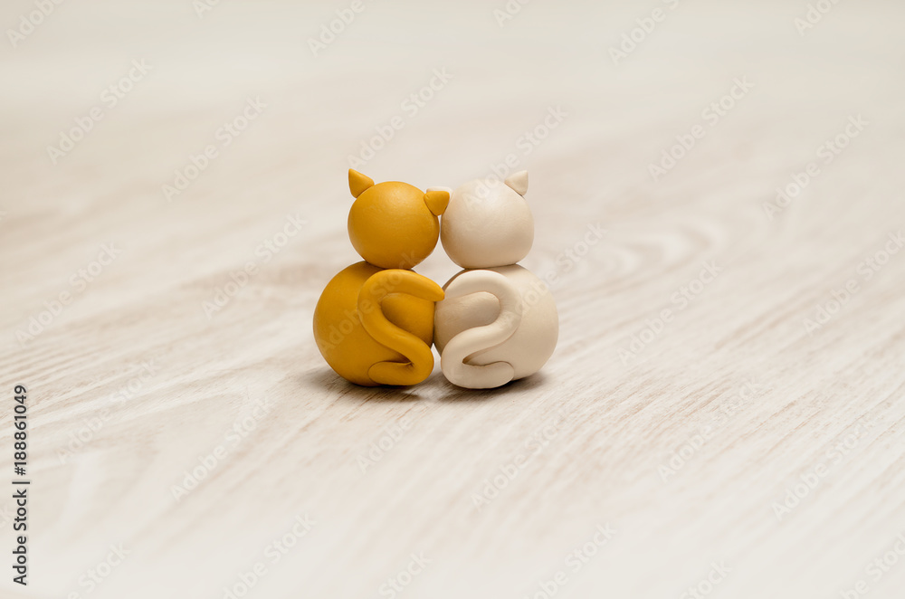 Two minimalistic animal figures in love. Lovely cat plasticine models having tails in heart shape. Happy Valentine's Day.