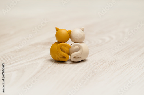Two minimalistic animal figures in love. Lovely cat plasticine models having tails in heart shape. Happy Valentine's Day.