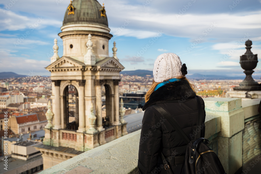 Obraz premium Young woman is looking at the St. Stephen's Basilica dome and cityscape of Budapest from dome terrace of St. Stephen's Basilica in BudaPest, Hungary