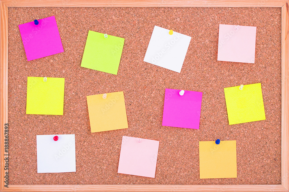 Cork board wood background with post it notes in different radiant colours. Cork board surface. Close up background of cork board wood surface with colorful notes. Cork table. Cork board wood background with post it notes in different radiant colours. Cork board surface. Close up background of cork board wood surface with colorful notes. Cork table.