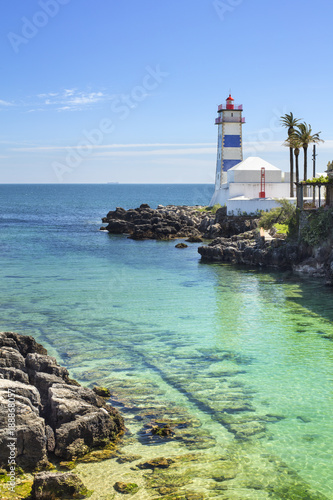 old colored lighthouse with emerald water in sunny day in Portugal