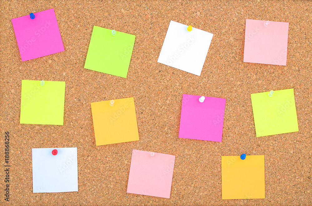 Cork board wood background with post it notes in different radiant colours. Cork board surface. Close up background of cork board wood surface with colorful notes. Cork table. Cork board wood background with post it notes in different radiant colours. Cork board surface. Close up background of cork board wood surface with colorful notes. Cork table.