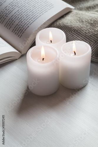 Candles and book with cozy blanket
