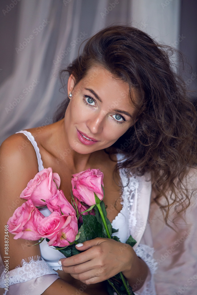 girl in lingerie standing by the bed with flowers girl in lingerie standing by the bed with flowers