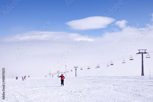 Kayak yapmaya giden kayakçı, arka planda bulutlar ve karlı dağlar. Kayseri Erciyes.