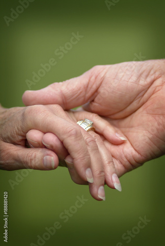 Closeup of a Married Senior Citizens Holding Hands. A loving closeup scene of a senior married couple holding hands with wedding rings.