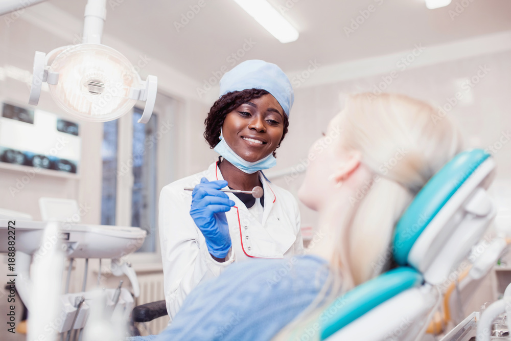 Φωτογραφία young black girl doctor dentist treats white girl's teeth