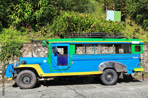 Bild auf Leinwand Filipino green-blue-yellow dyipni-jeepney car stationed in Banaue town-Ifugao province-Philippines