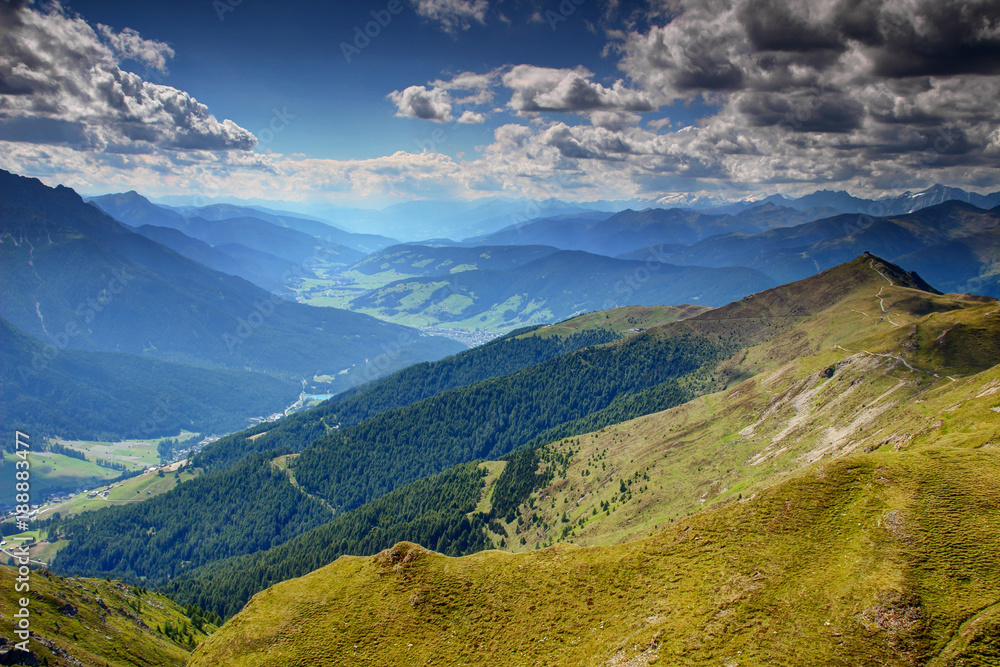 Summer sunshine over grassy Carnic main ridge, Helm peak, Val di Sesto and Pusteria valleys, Sesto Sexten, San Candido Innichen villages, Dolomites Tauern and Zillertal Alps, Alto Adige Sudtirol Italy