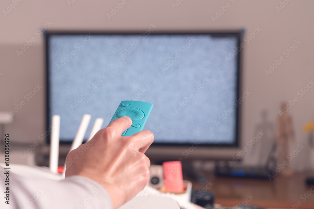 a women hand hold the remote control of the TV box in the living room, the blank screen TV