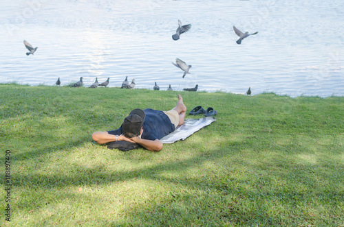 A man sleeps near the lake