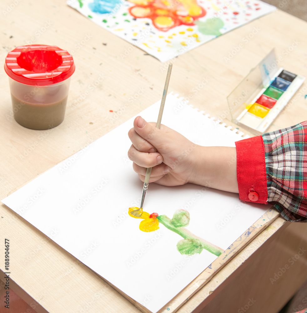A girl draws a drawing with paints on a sheet A girl draws a drawing with paints on a sheet