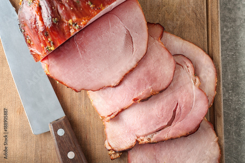 Delicious sliced honey baked ham on wooden board, closeup