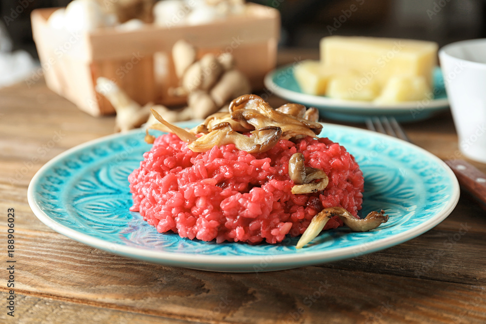Plate of tasty beetroot risotto with mushrooms on table, closeup Plate of tasty beetroot risotto with mushrooms on table, closeup