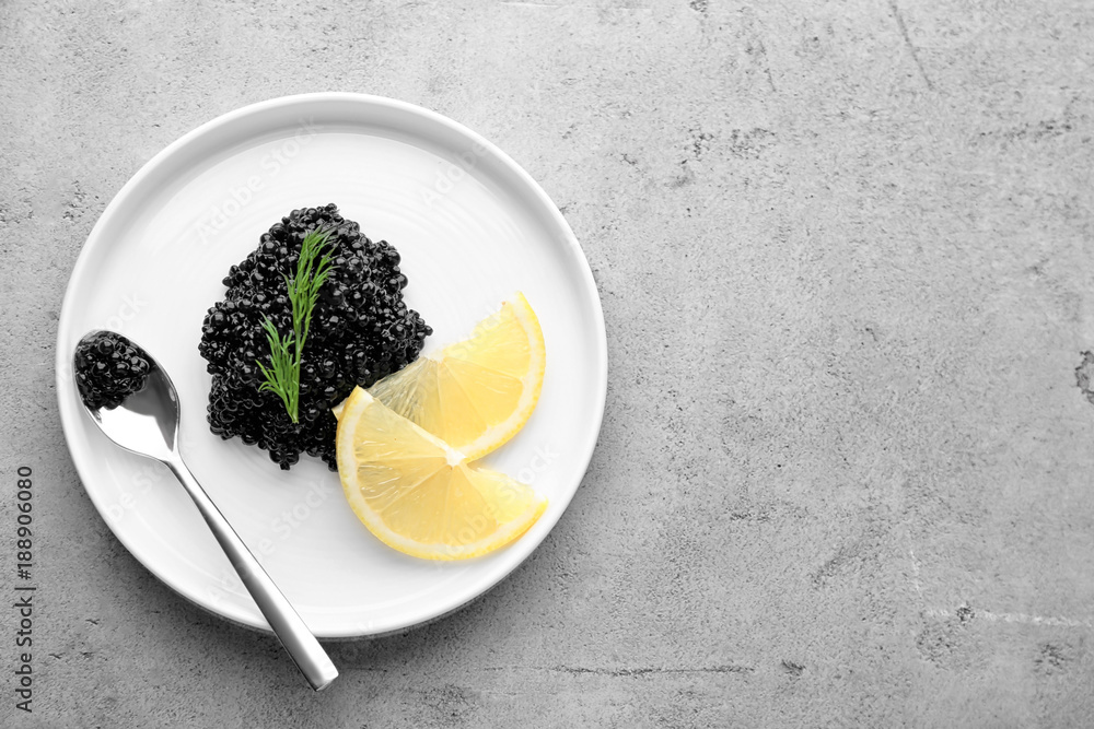 Plate with black caviar and slices of lemon on table Plate with black caviar and slices of lemon on table