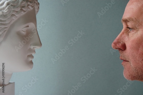 Two opposite faces. Man and sculpture. Eternity and life. photo