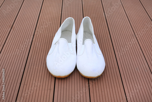 White casual shoes on wood plank background.