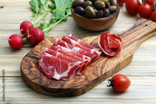 antipasto carne di porco salata su tagliere di legno sfondo tavolo di cucina