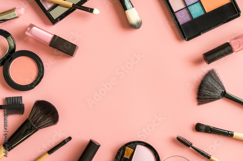 Set of make up brushes and cosmetics on pink background