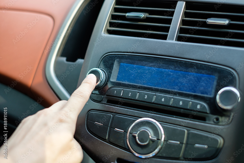 Man hand adjusting press button car audio