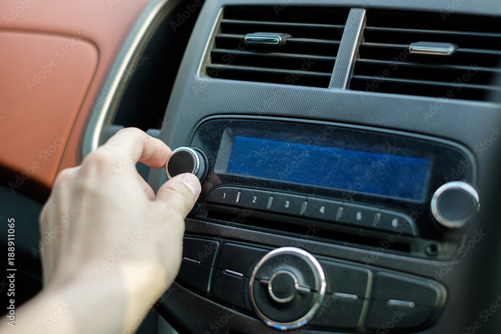 Man hand adjusting dial button car audio