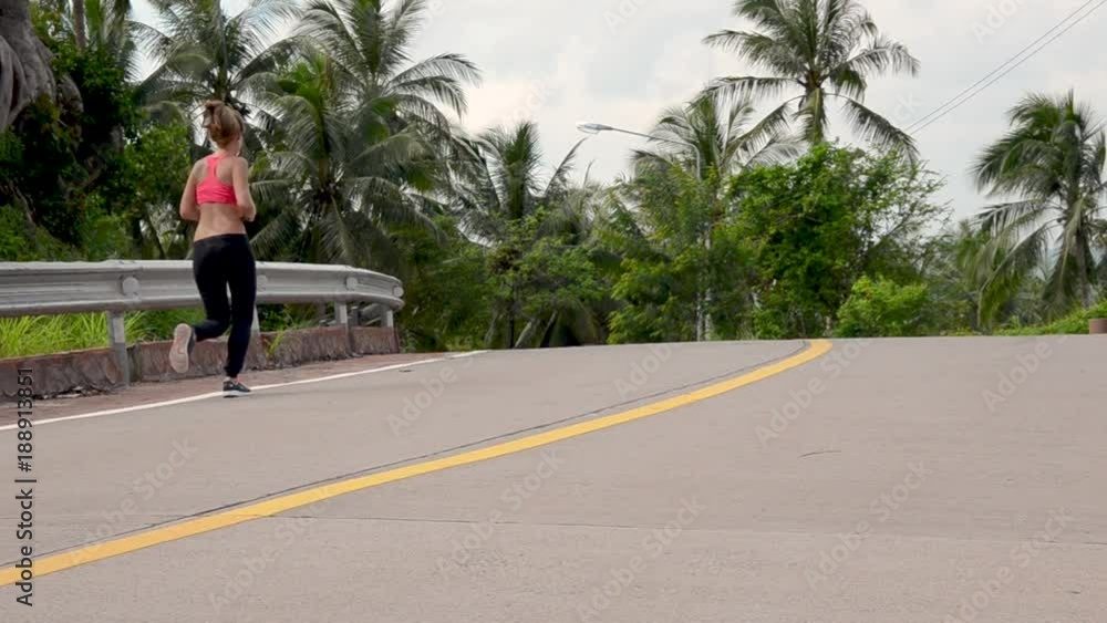 fitness woman running at tropical forest trail fitness woman running at tropical forest trail