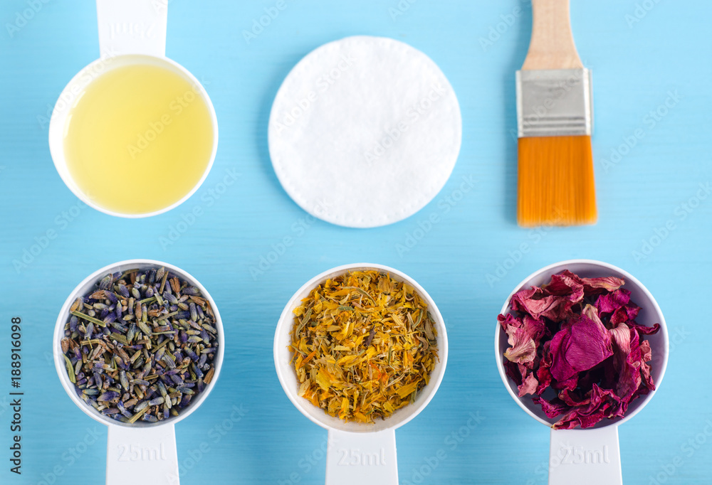 Plastic scoops with olive oil and various healing herbs - dry marigold, lavender and dog rose flowers. Aromatherapy, herbal medicine and natural skin care concept. Top view, copy space. Plastic scoops with olive oil and various healing herbs - dry marigold, lavender and dog rose flowers. Aromatherapy, herbal medicine and natural skin care concept. Top view, copy space.