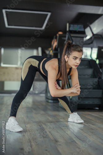 Sporty woman stretching in gym
