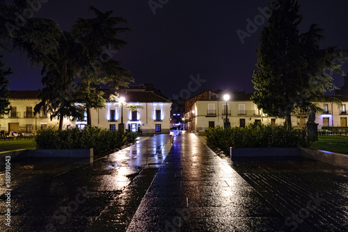 Square called "San Diego" with cobbles wet by rain with light re